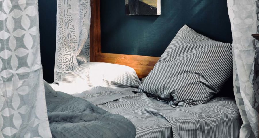 Zu sehen ein Schlafzimmer, mit Fokus auf das Bett und dessen schöne Bezüge