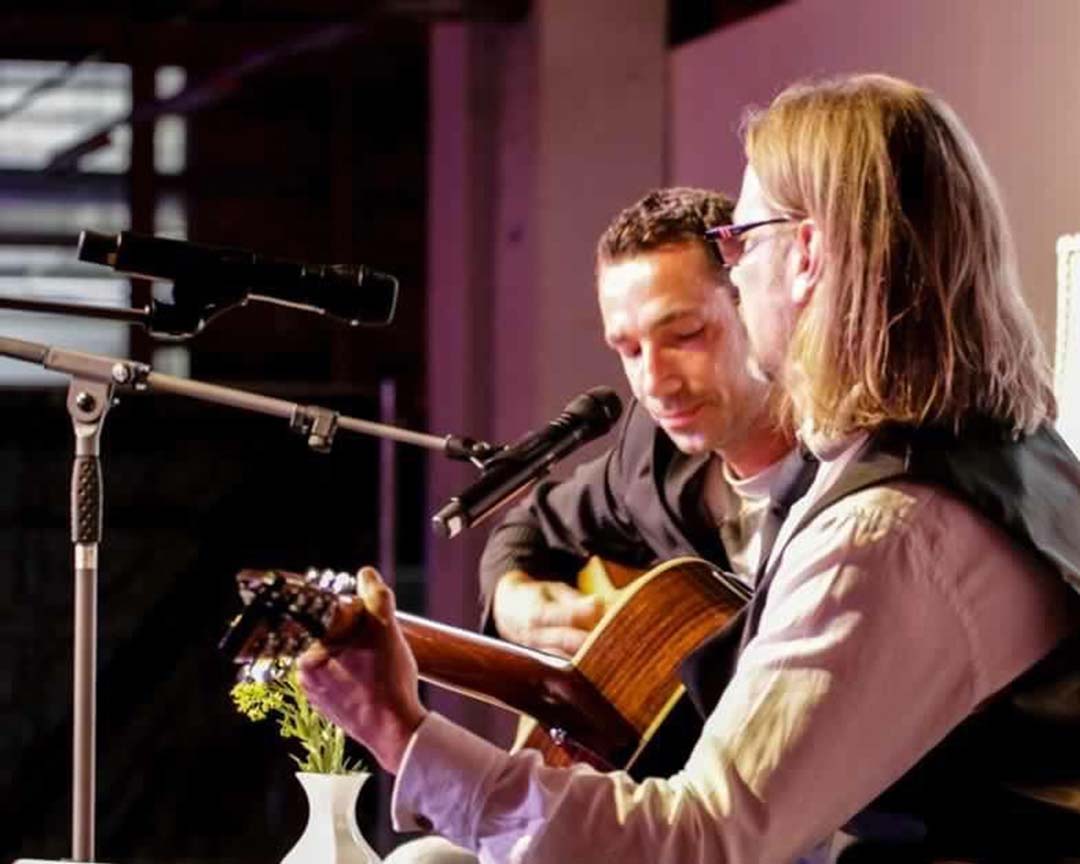 Zwei Männer mit ihren Instrumenten, die ein Konzert geben.