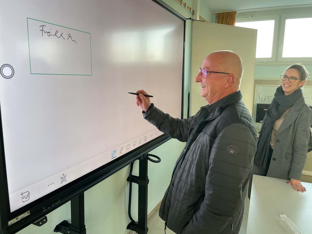 Amtsleiter Peter Fröhlich und Abteilungsleiterin Claudia Grohmann testen eine interaktive Tafel in der Ostsee-Schule in Wismar.