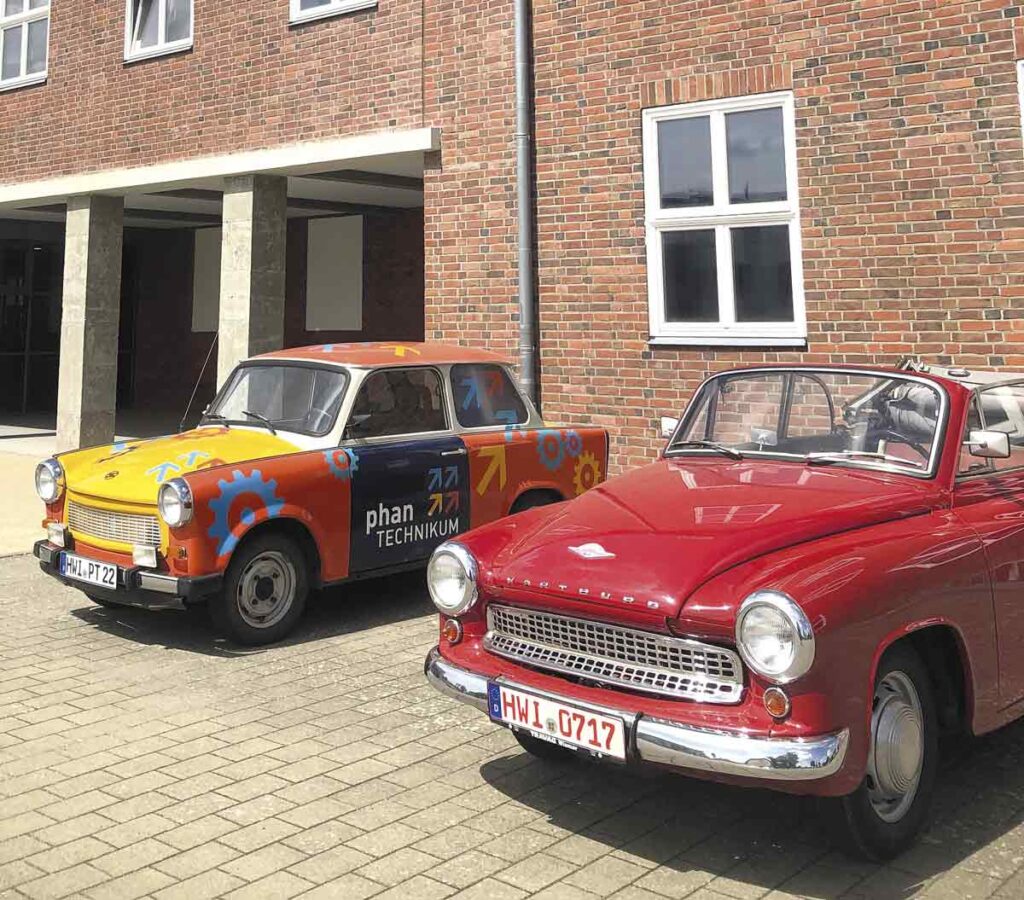 bunter Trabbi 601 und roter Wartburg 311 Cabrio vor dem Phantechnikum in Wismar